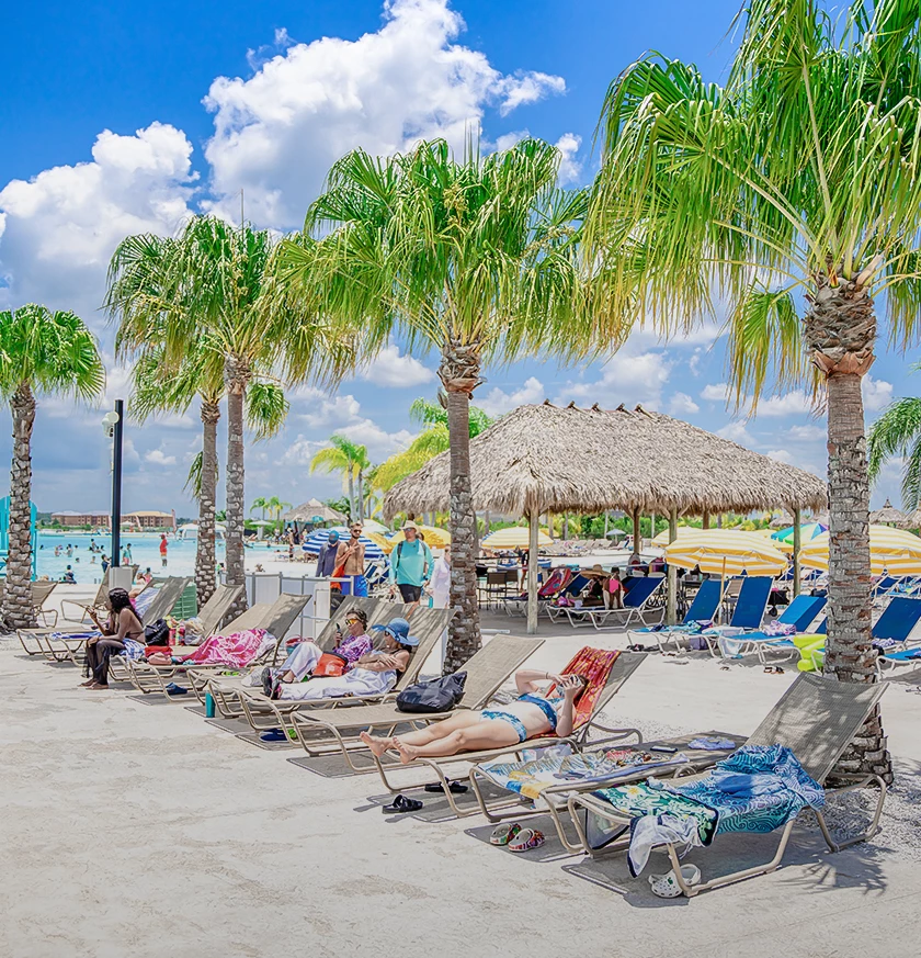a group of people sitting in lounge chairs on a beach