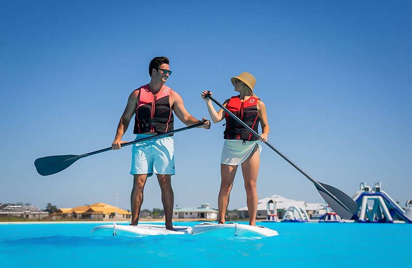 a man and woman on paddle boards in water