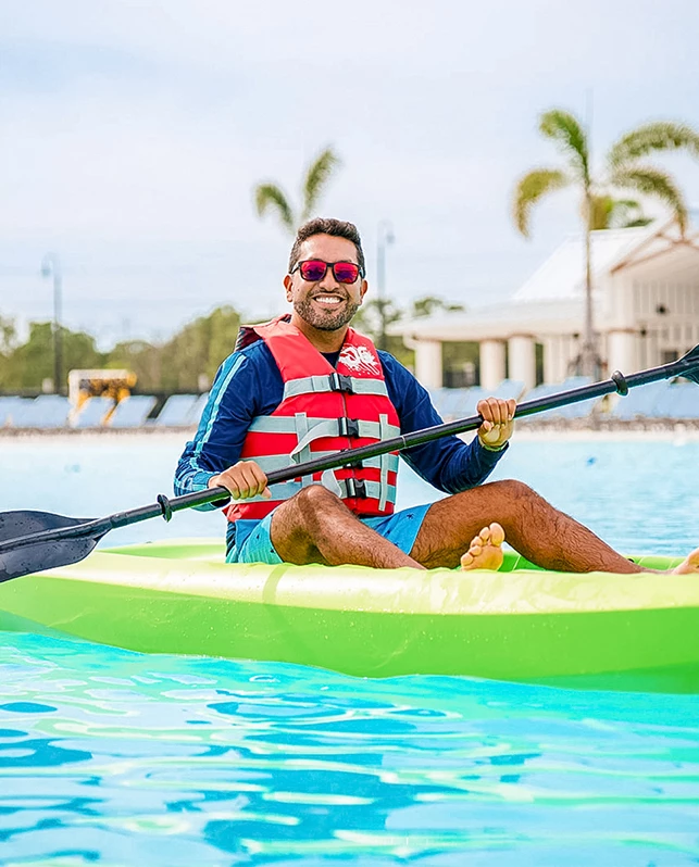 a man in a life jacket on a green kayak