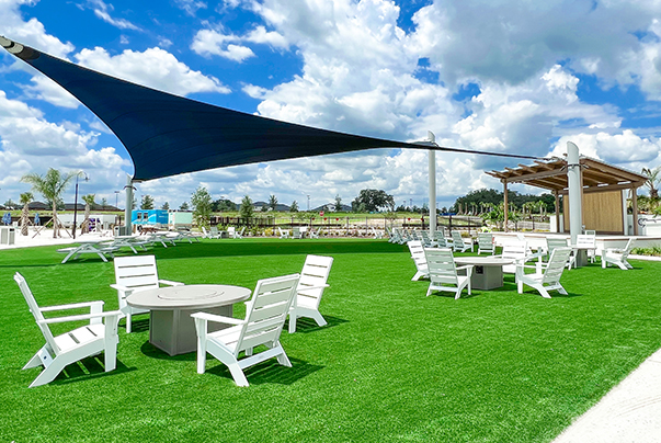 a white chairs and tables on a green lawn