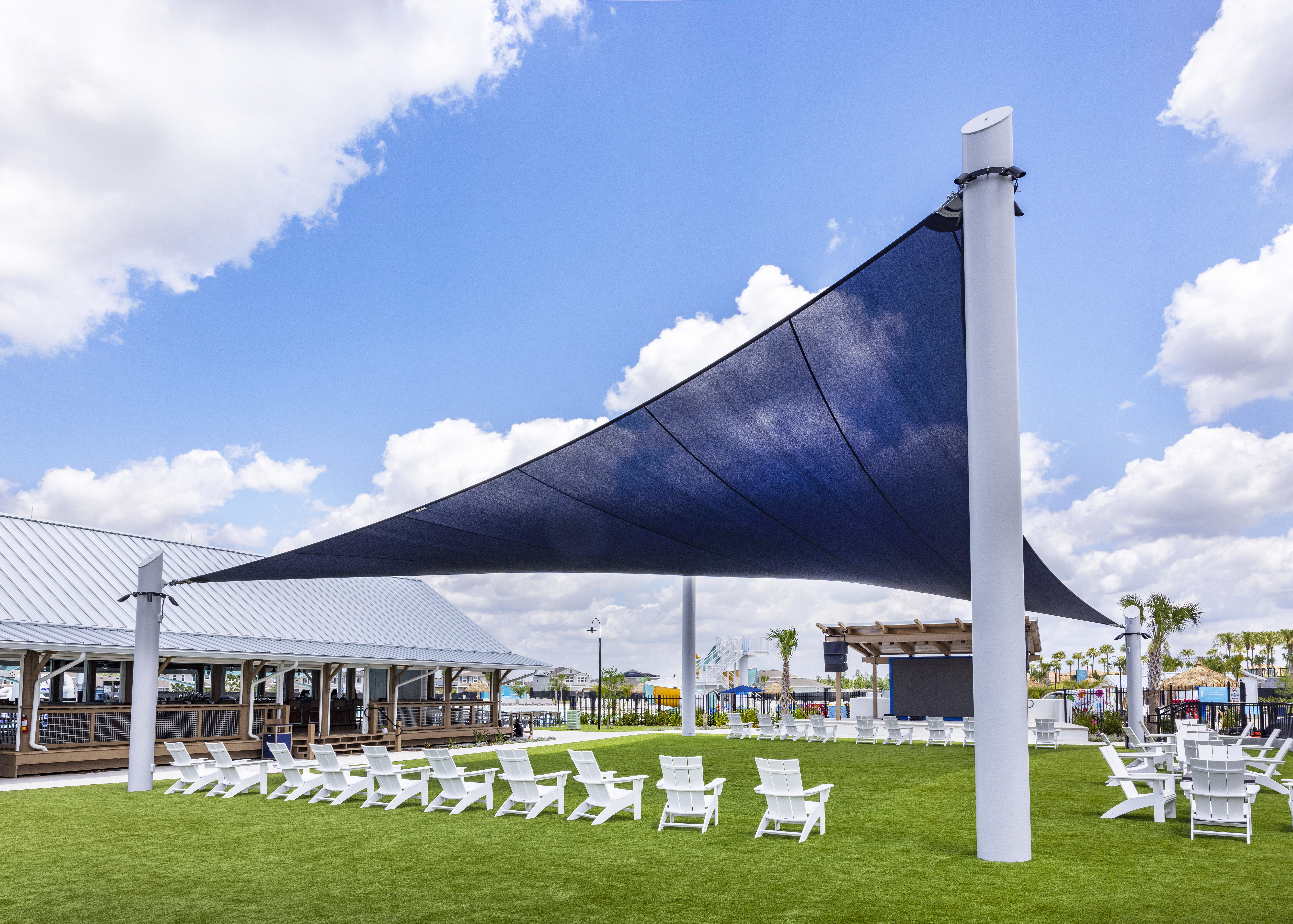 a white chairs and tables on a green lawn