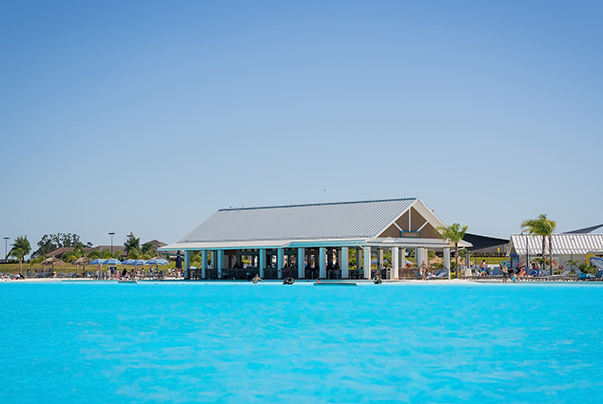 a pool with a building and people in the background