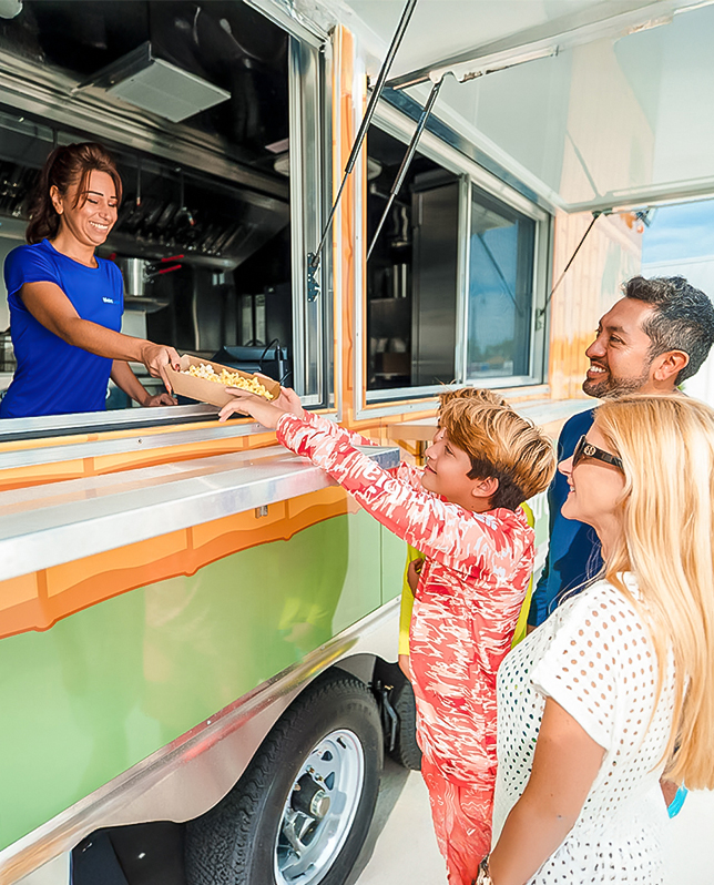 a group of people standing next to a food truck