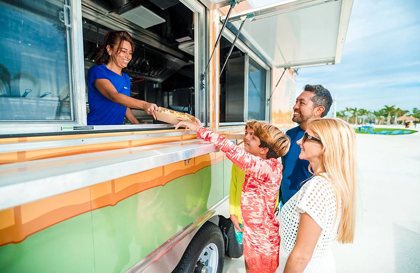 a group of people standing in front of a food truck