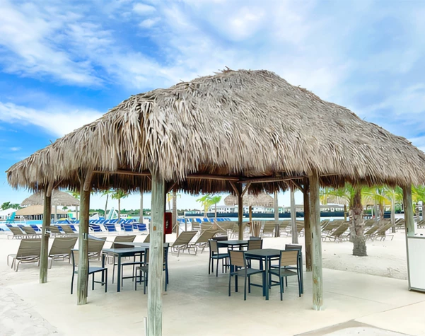 a hut with chairs and tables on a beach