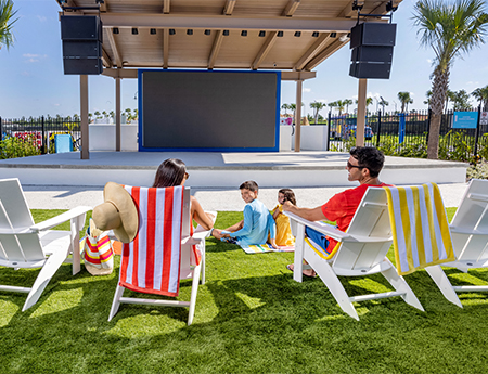 a group of people sitting in chairs on grass