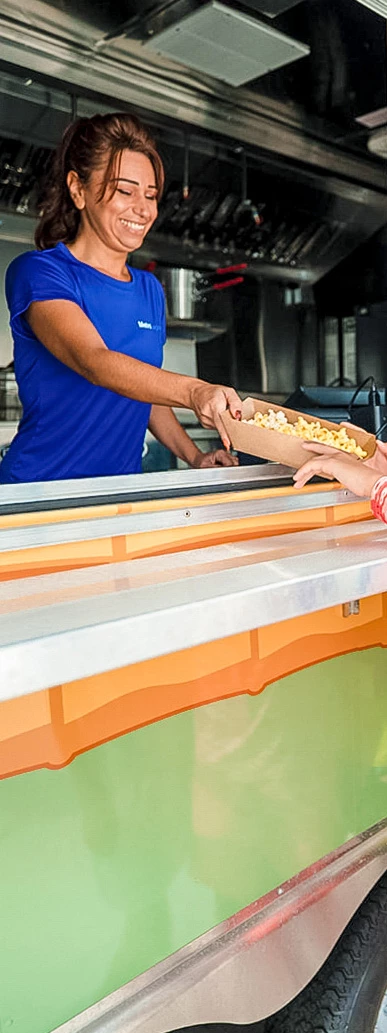 a person handing a box of popcorn to a woman