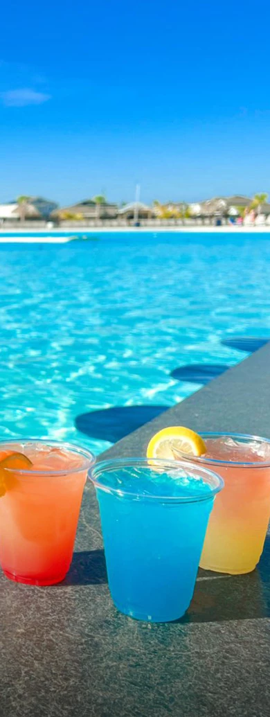 a group of drinks next to a pool
