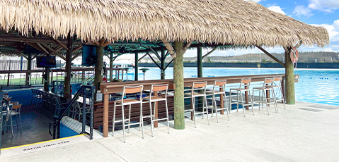 a row of stools next to a thatched roof