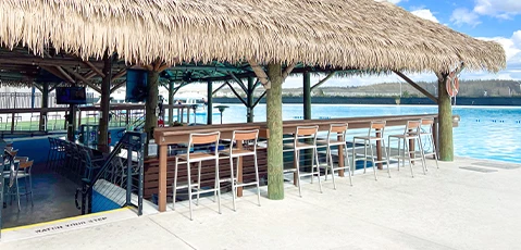 a row of stools next to a thatched roof