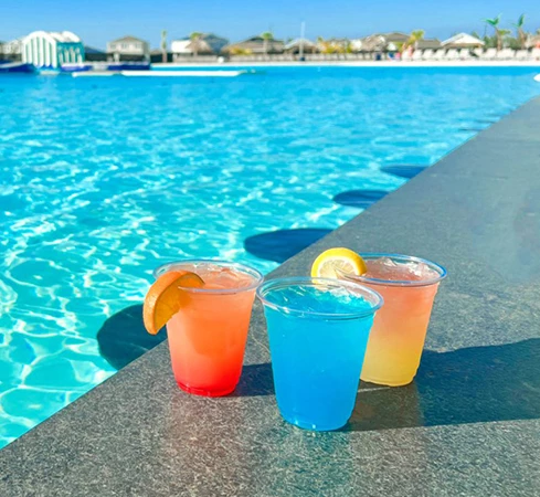 a group of drinks next to a pool