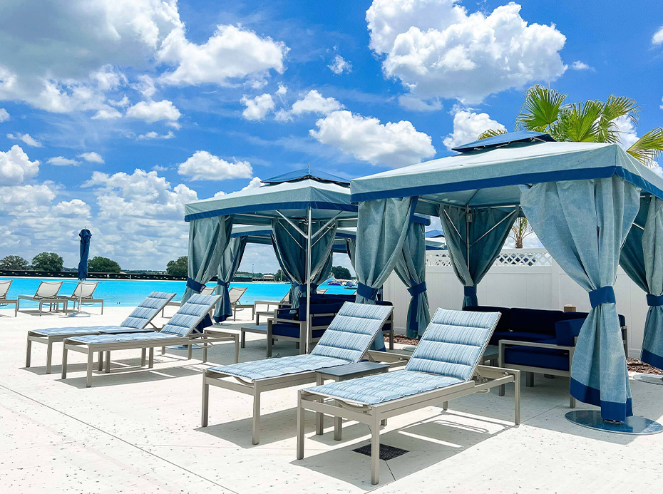 a group of lounge chairs and umbrellas on a patio