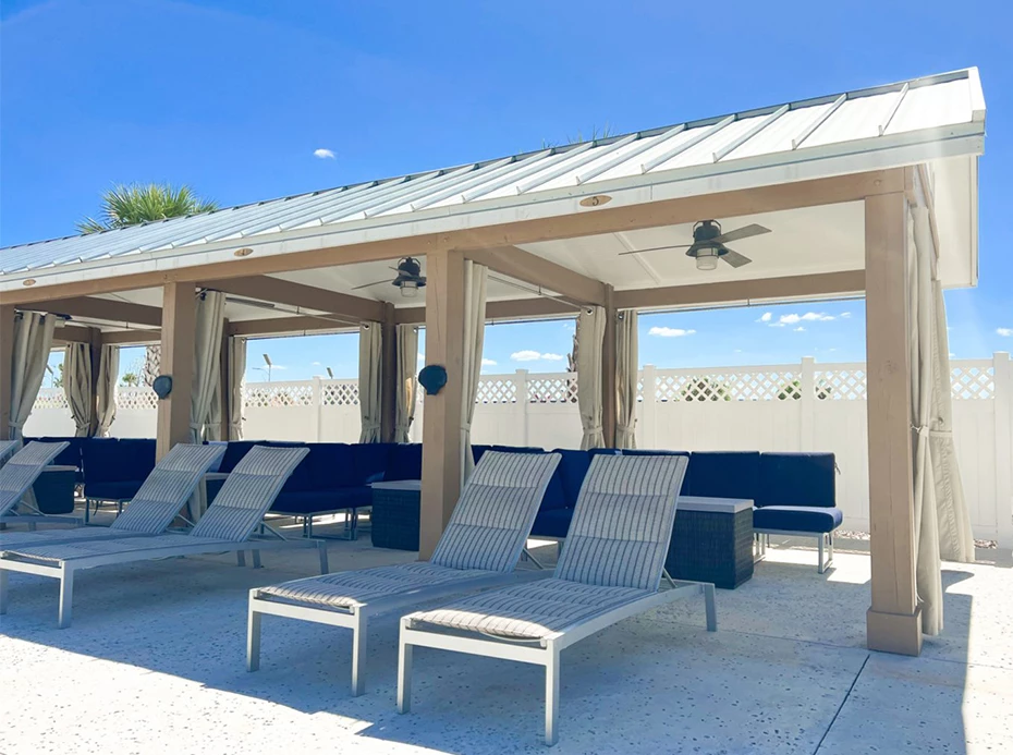 a group of lounge chairs under a covered patio
