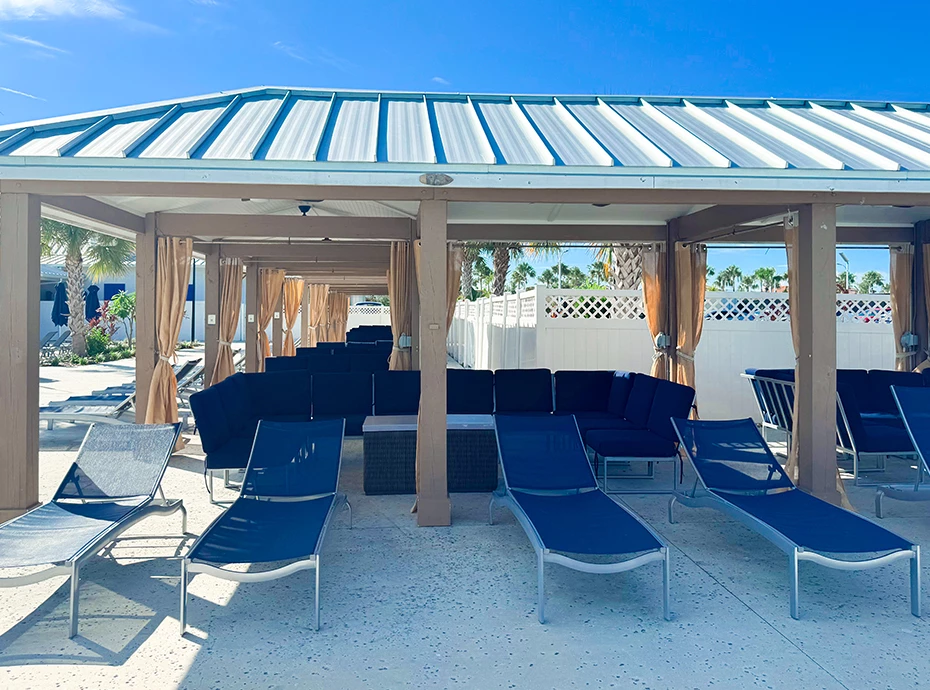 a group of lounge chairs under a covered gazebo