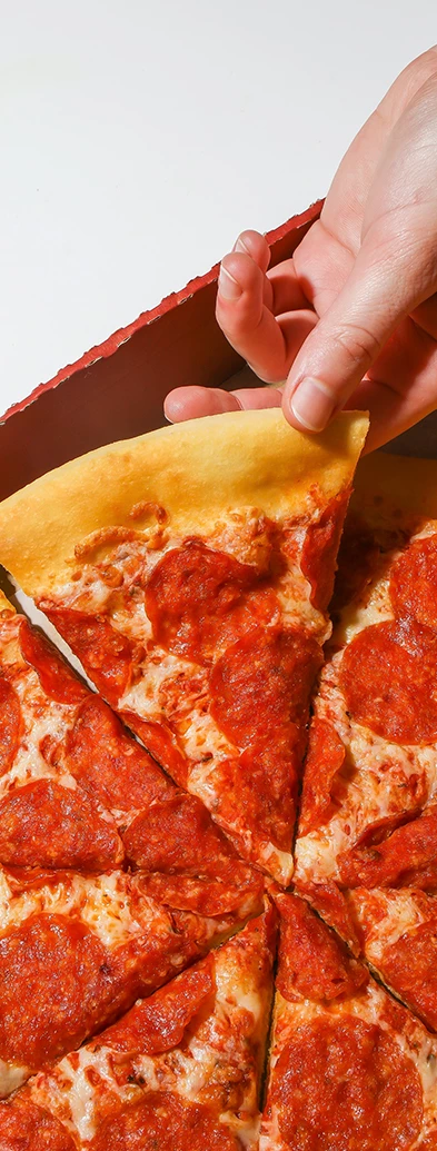 a hand holding a slice of pizza