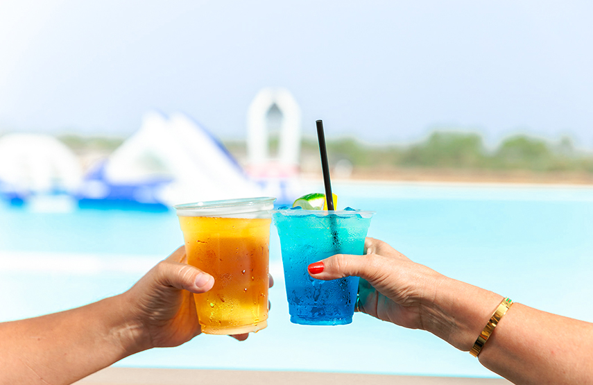 two hands holding cups with drinks