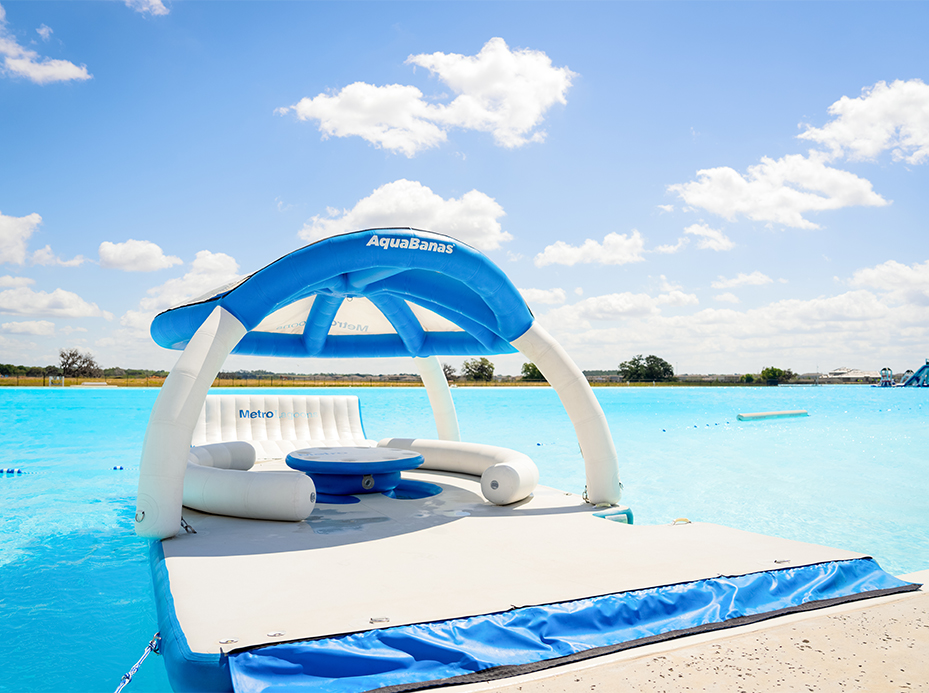 a floating raft with a table and chairs in the water