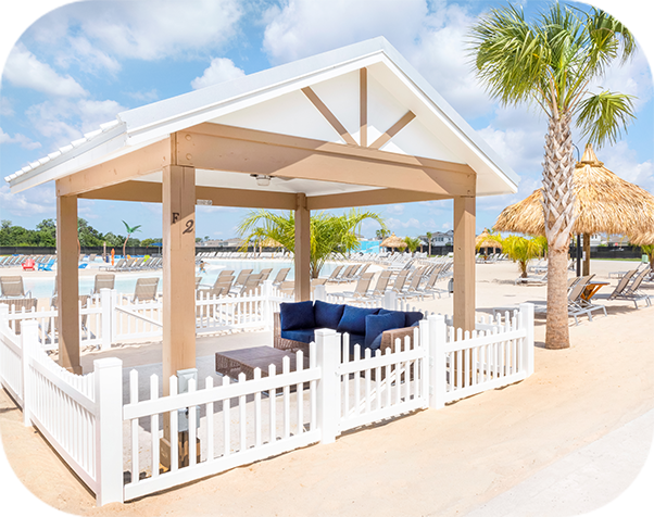 a white fence and a white structure with a blue couch and chairs