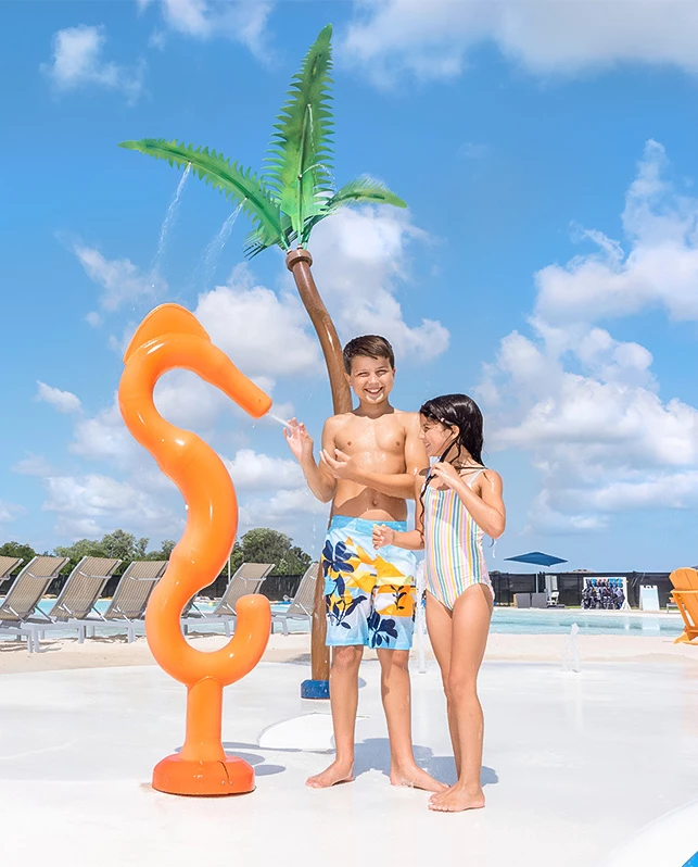 a boy and girl standing next to an orange object