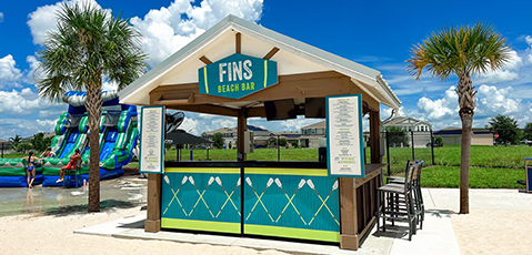 a beach bar with a sign