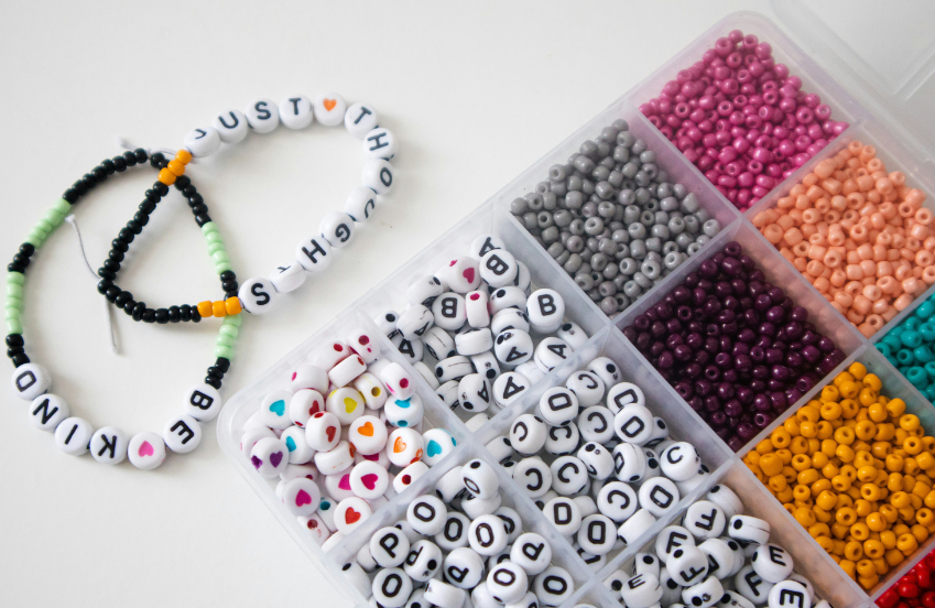 a plastic container with beads and a necklace