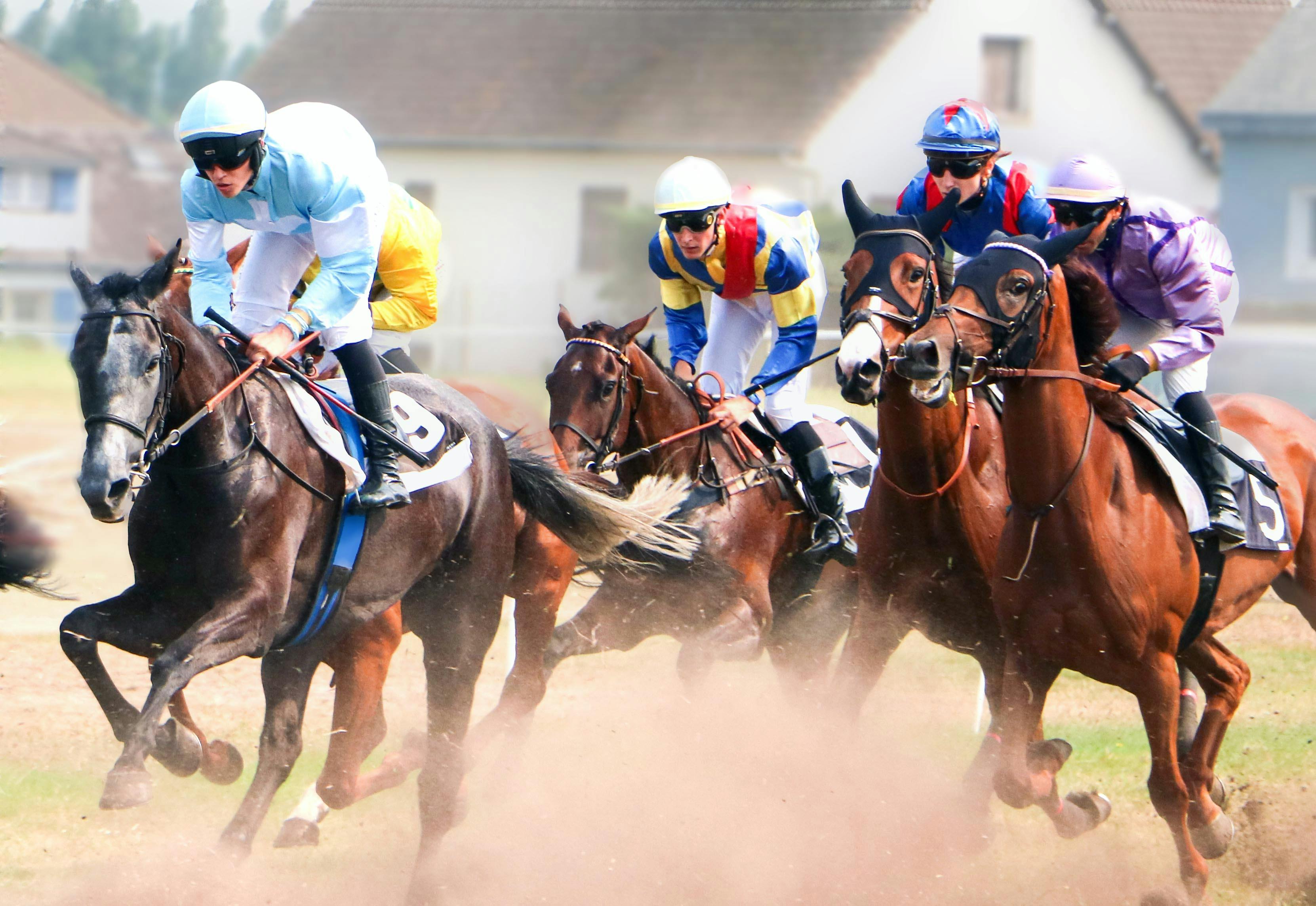 a group of jockeys riding horses