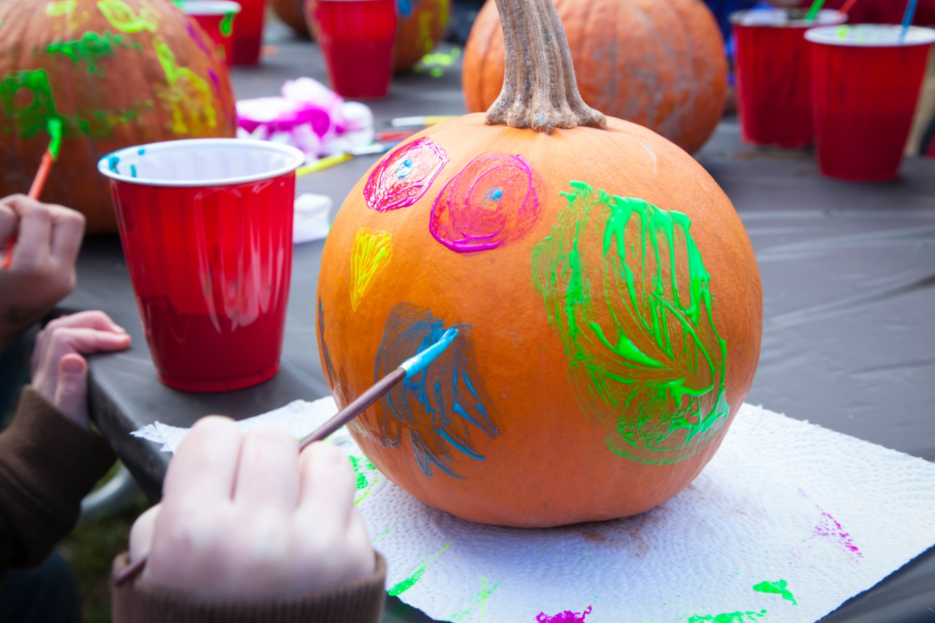 a hand painting a pumpkin