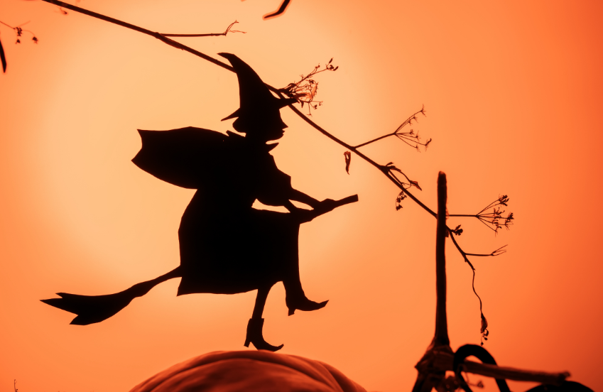 a silhouette of a person on a broomstick