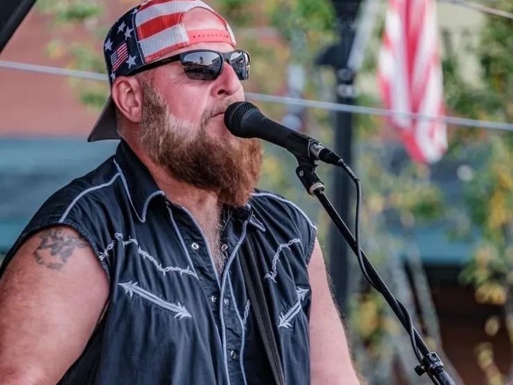 a man with a beard singing into a microphone