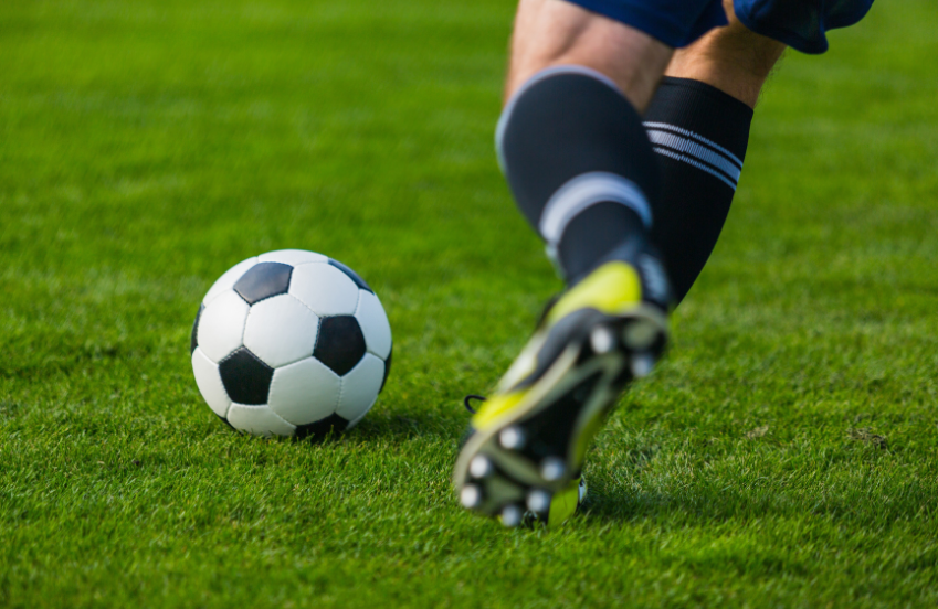 a football player kicking a football ball