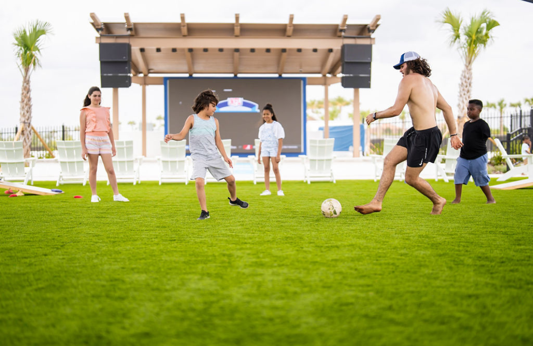 a man kicking a football ball on a grass field