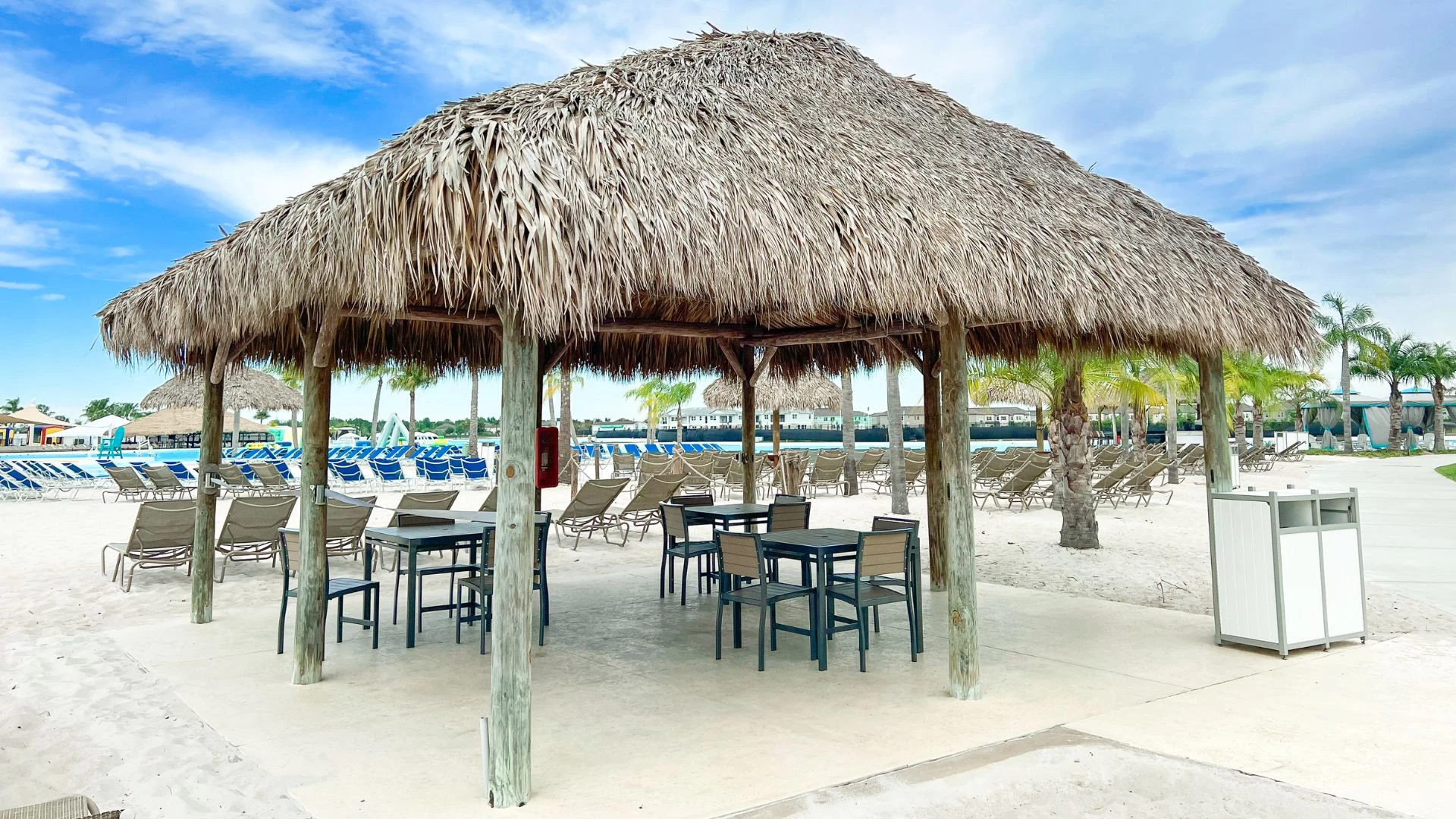 a hut with chairs and tables on a beach