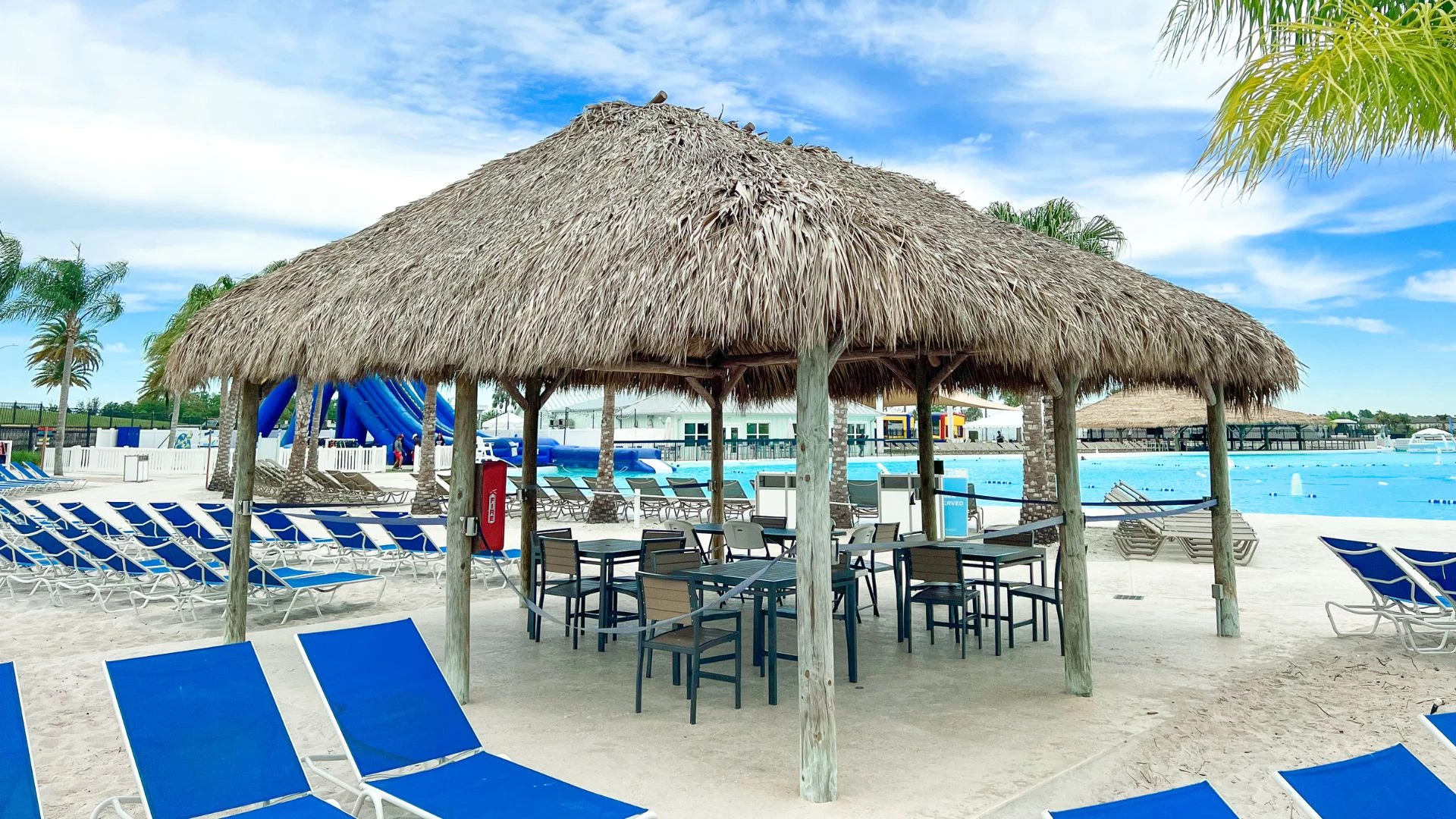 a hut with chairs and a table on a beach