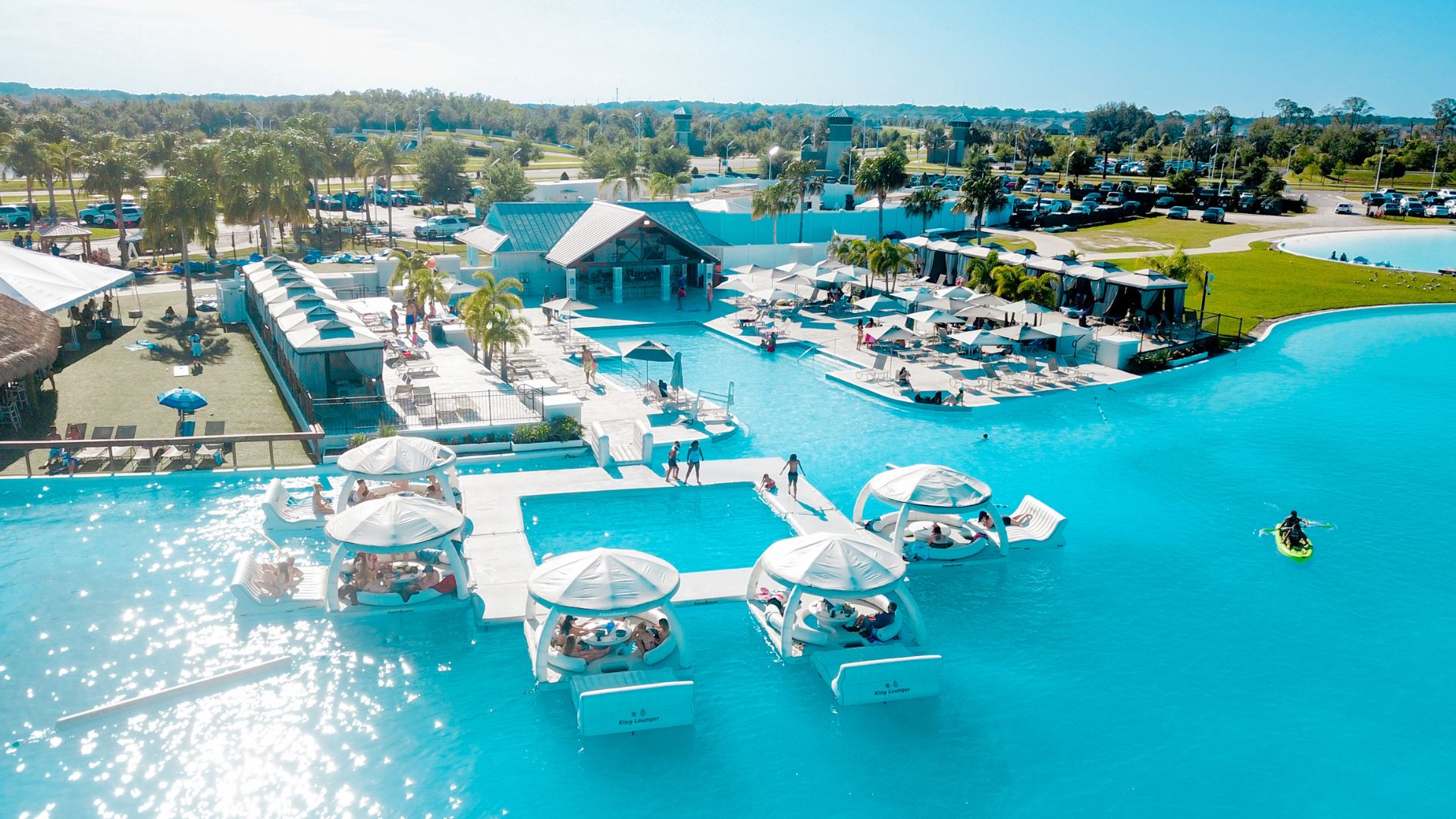 a pool with white tents and people in it