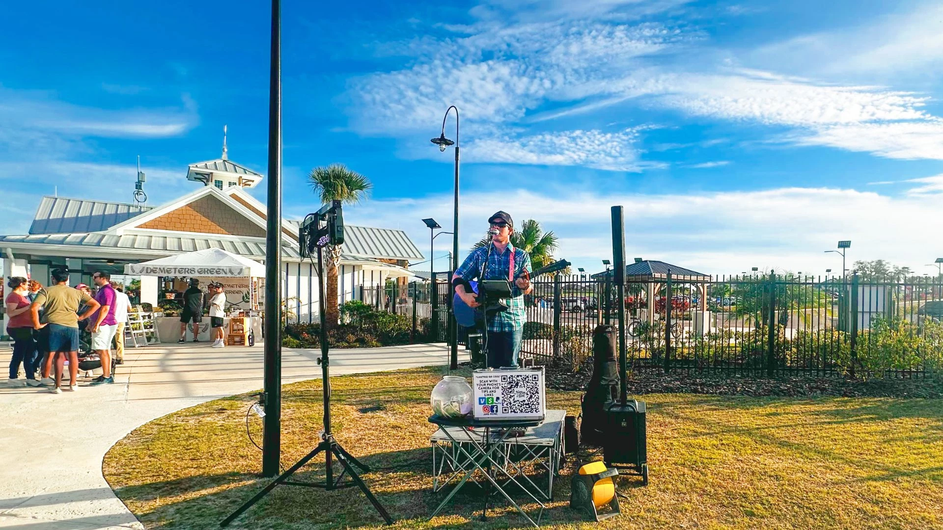 a man playing a guitar on a stand outside