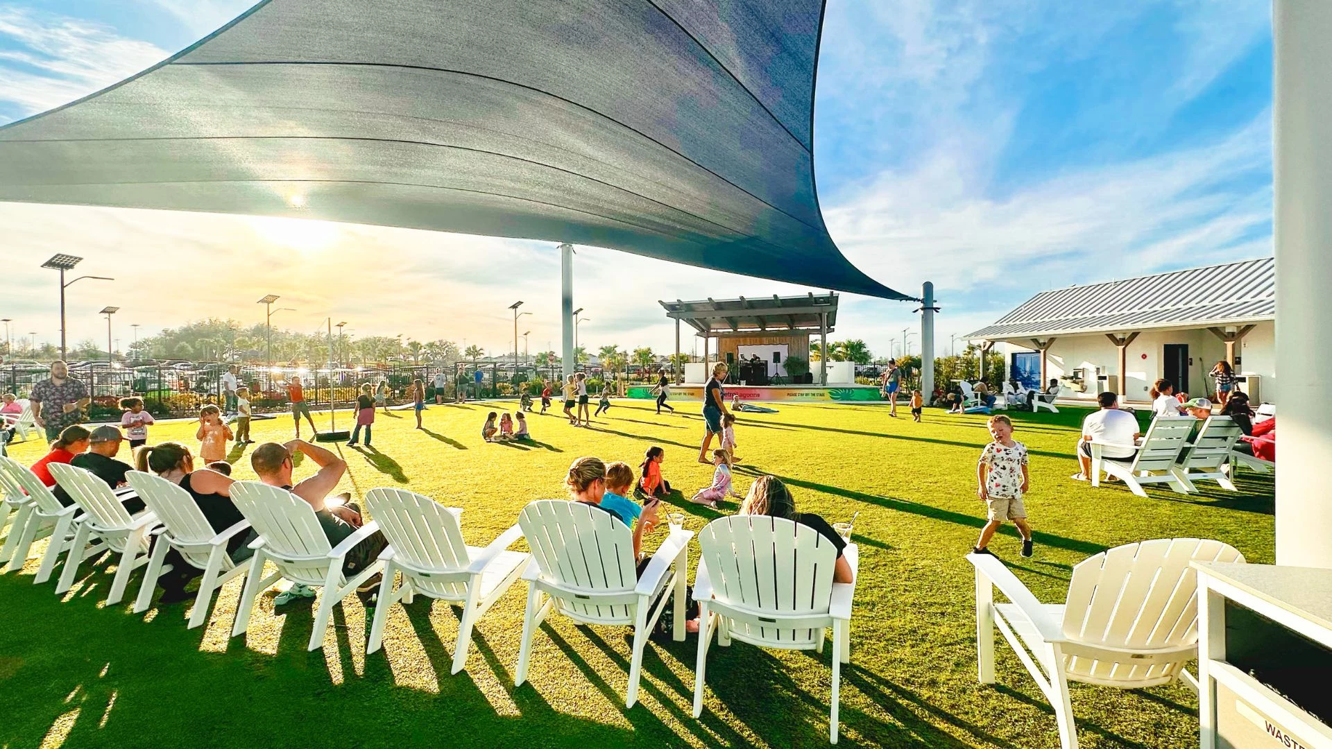 a group of people sitting in chairs on a green lawn