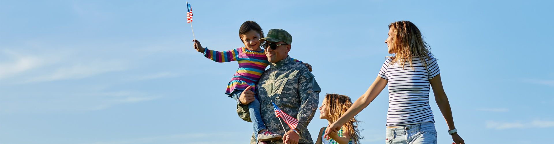 a man in military uniform holding a child on his shoulders