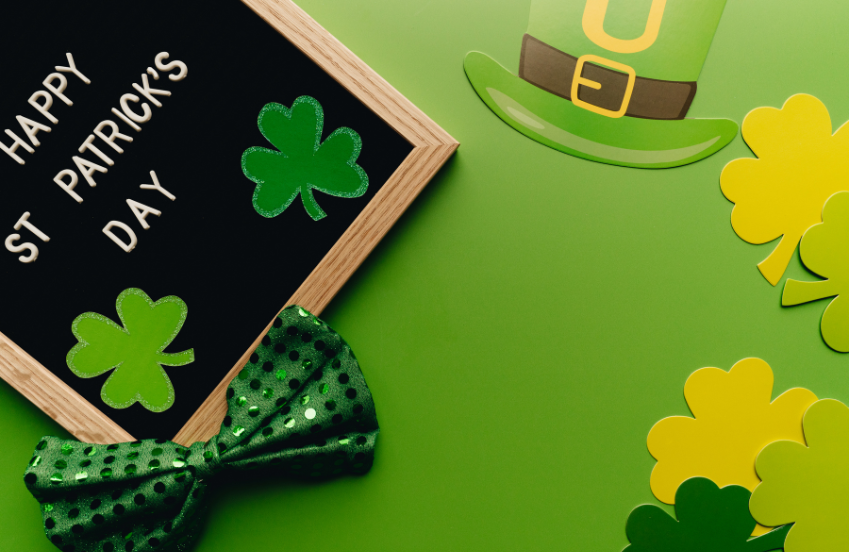 a black board with a bow tie and shamrocks on a green background