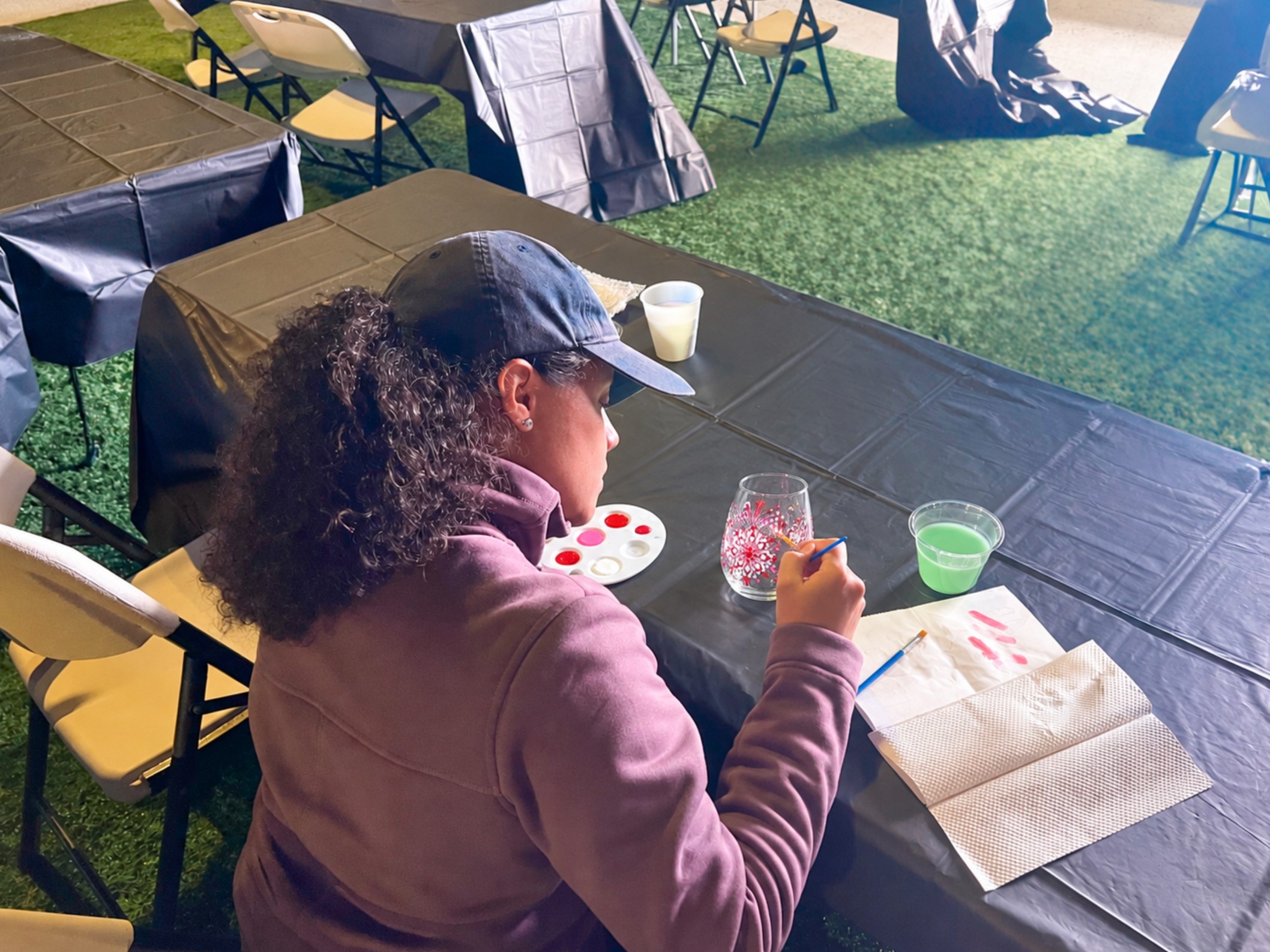a woman sitting at a table painting