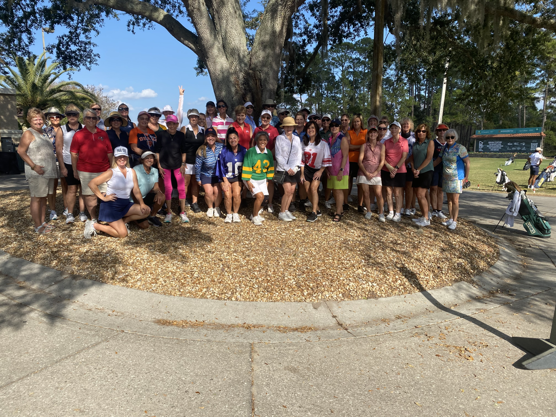 a group of people posing for a photo under a tree