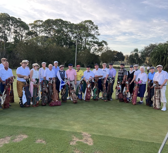 a group of people holding golf clubs