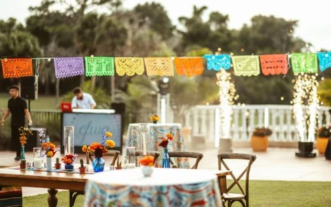 a table with flowers and a man in the background