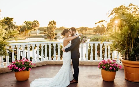 a bride and groom kissing on a balcony