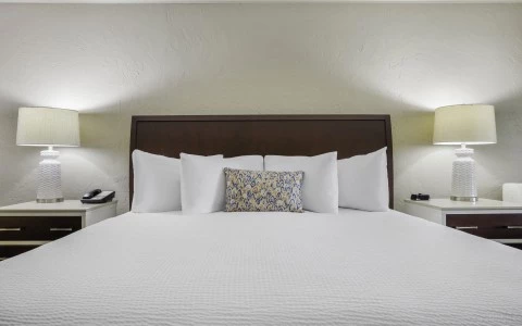 a bed with white sheets and pillows