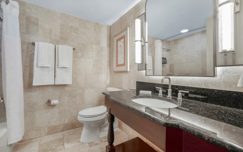 a bathroom with a marble countertop sink and a mirror