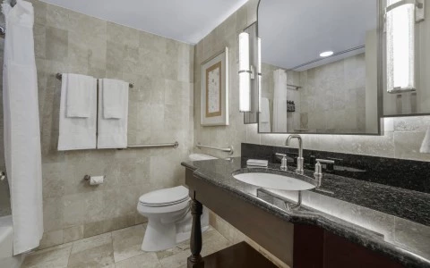 a bathroom with a marble countertop sink and a mirror