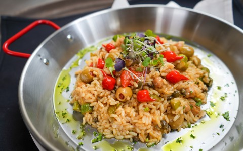 a bowl of rice with vegetables and herbs