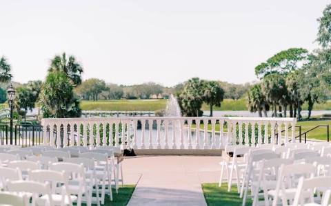 a white chairs and a fountain in front of a pond