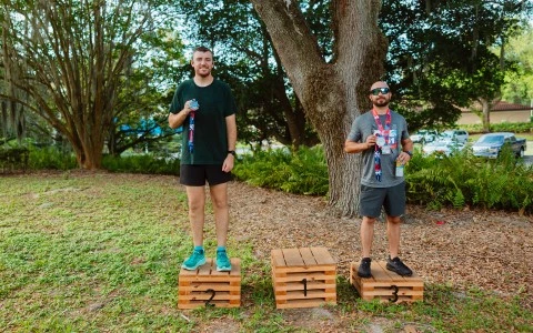 two men standing on wooden boxes with medals around them