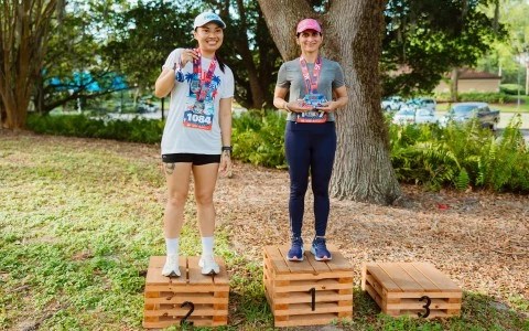 two women standing on wooden crates with numbers on them